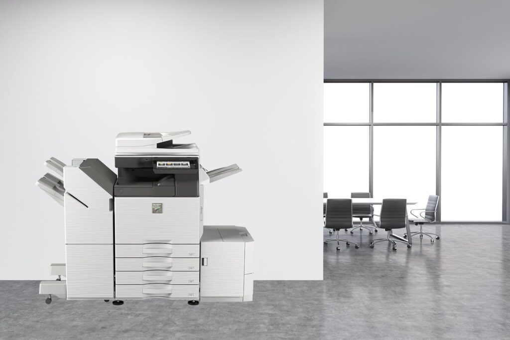 A black and white printer is sitting in an office next to a conference room.