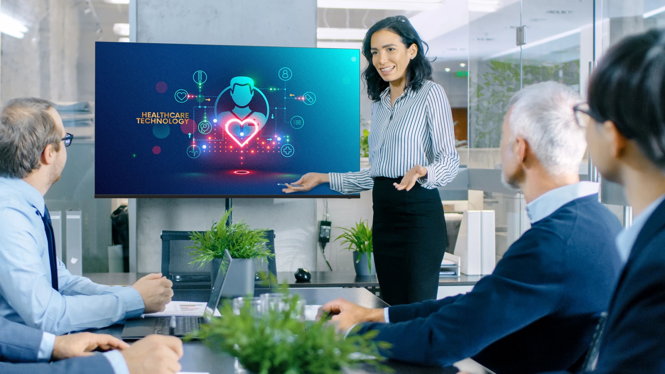 A woman is giving a presentation to a group of people in a conference room.