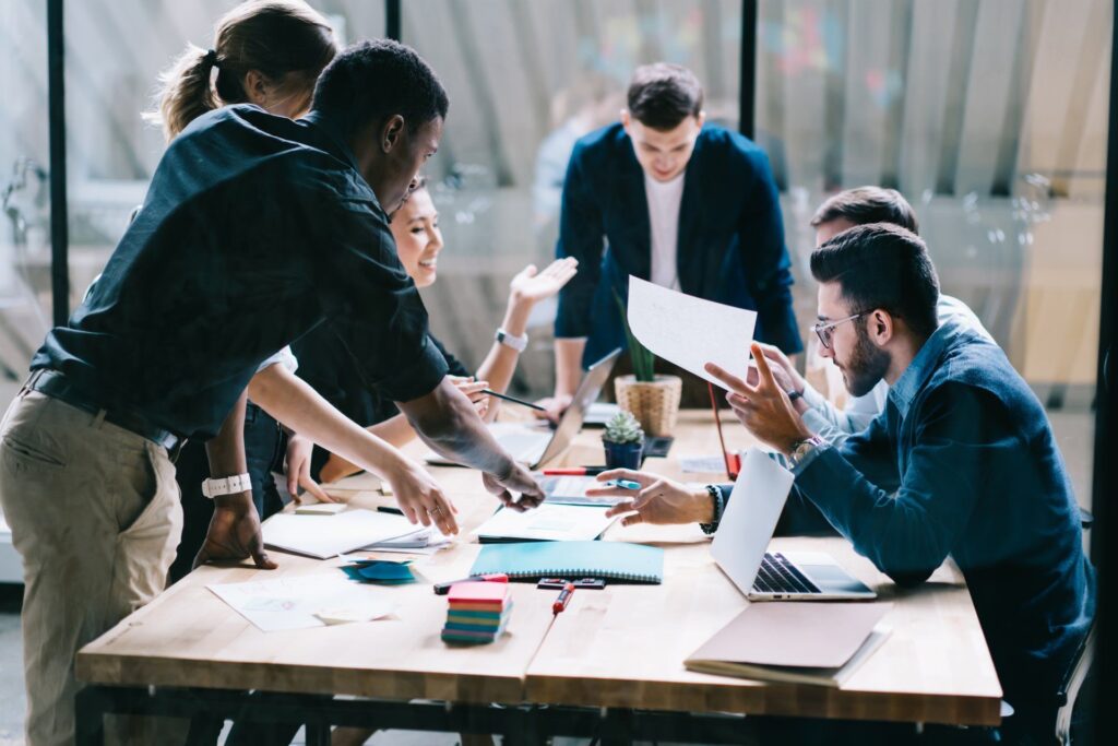 A group of people are sitting around a table having a meeting.