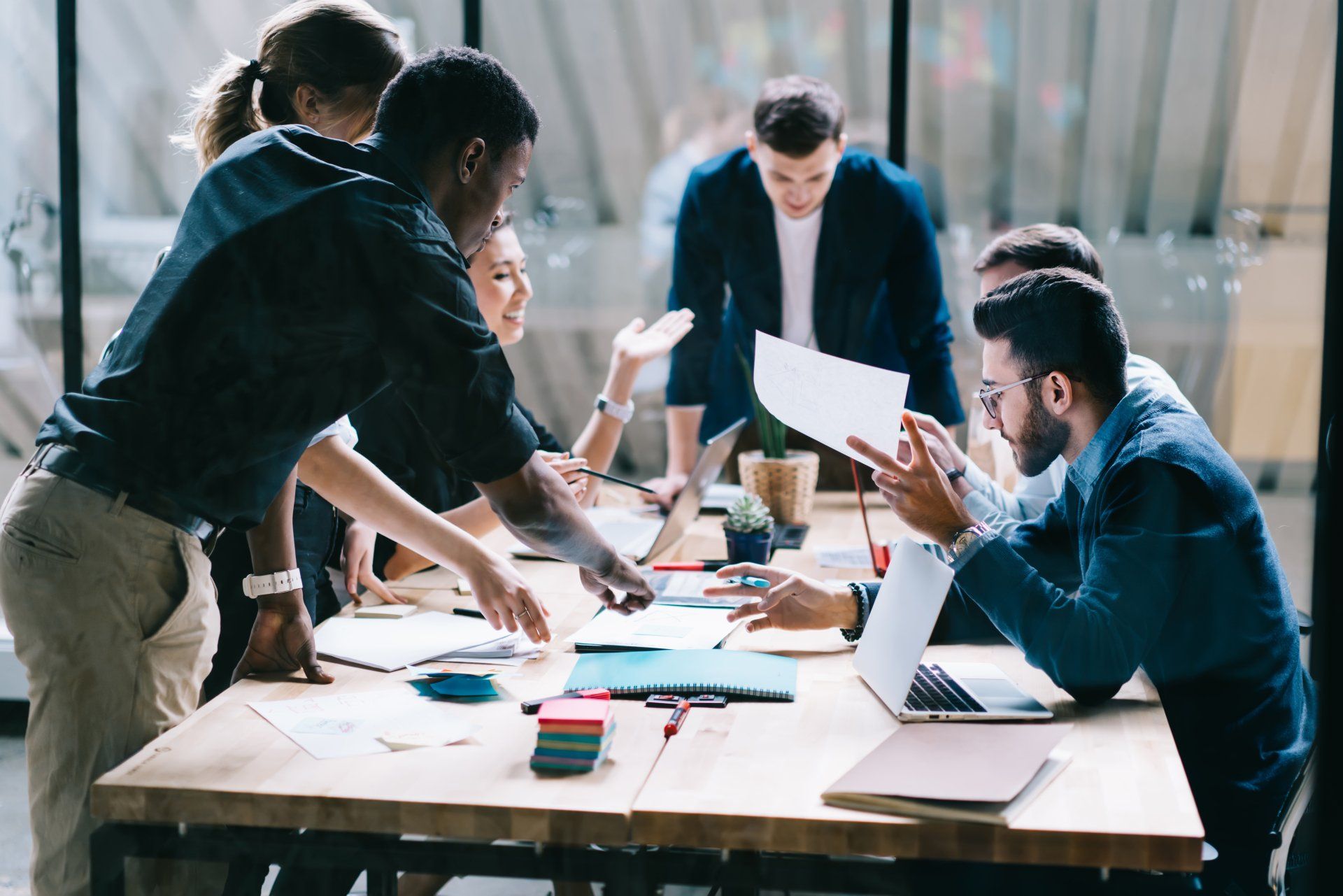 A group of people are sitting around a table having a meeting.