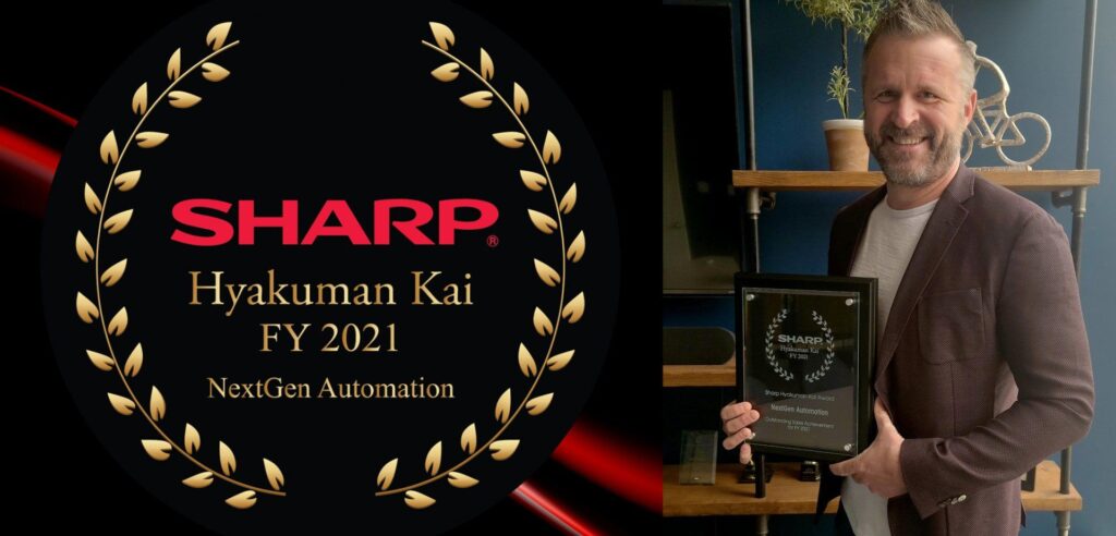 A man in a suit is holding a sharp award.