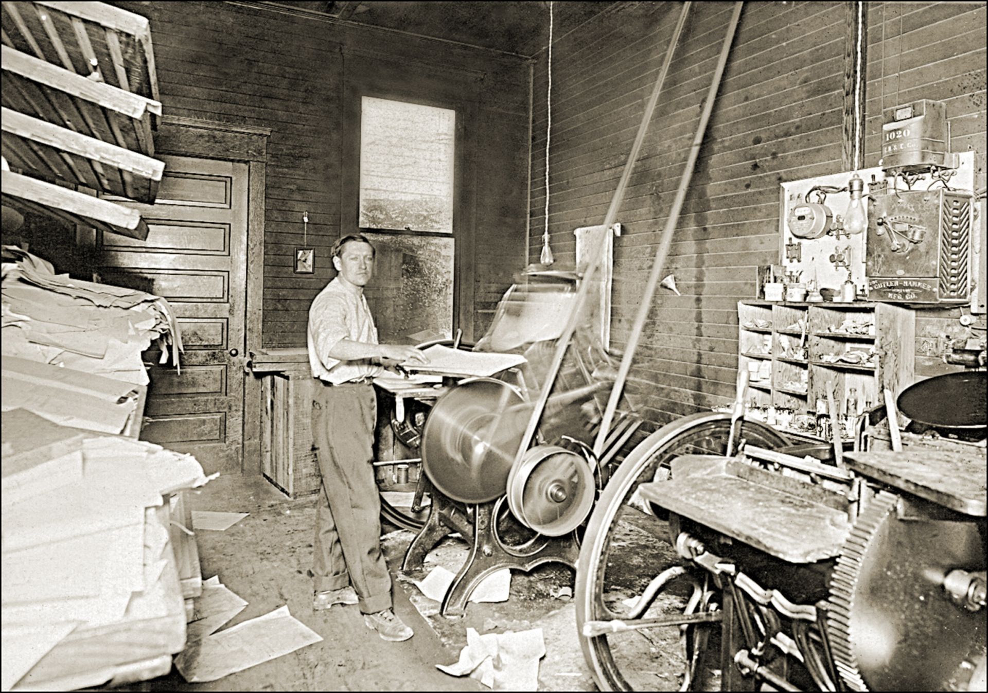A black and white photo of a man working on a machine