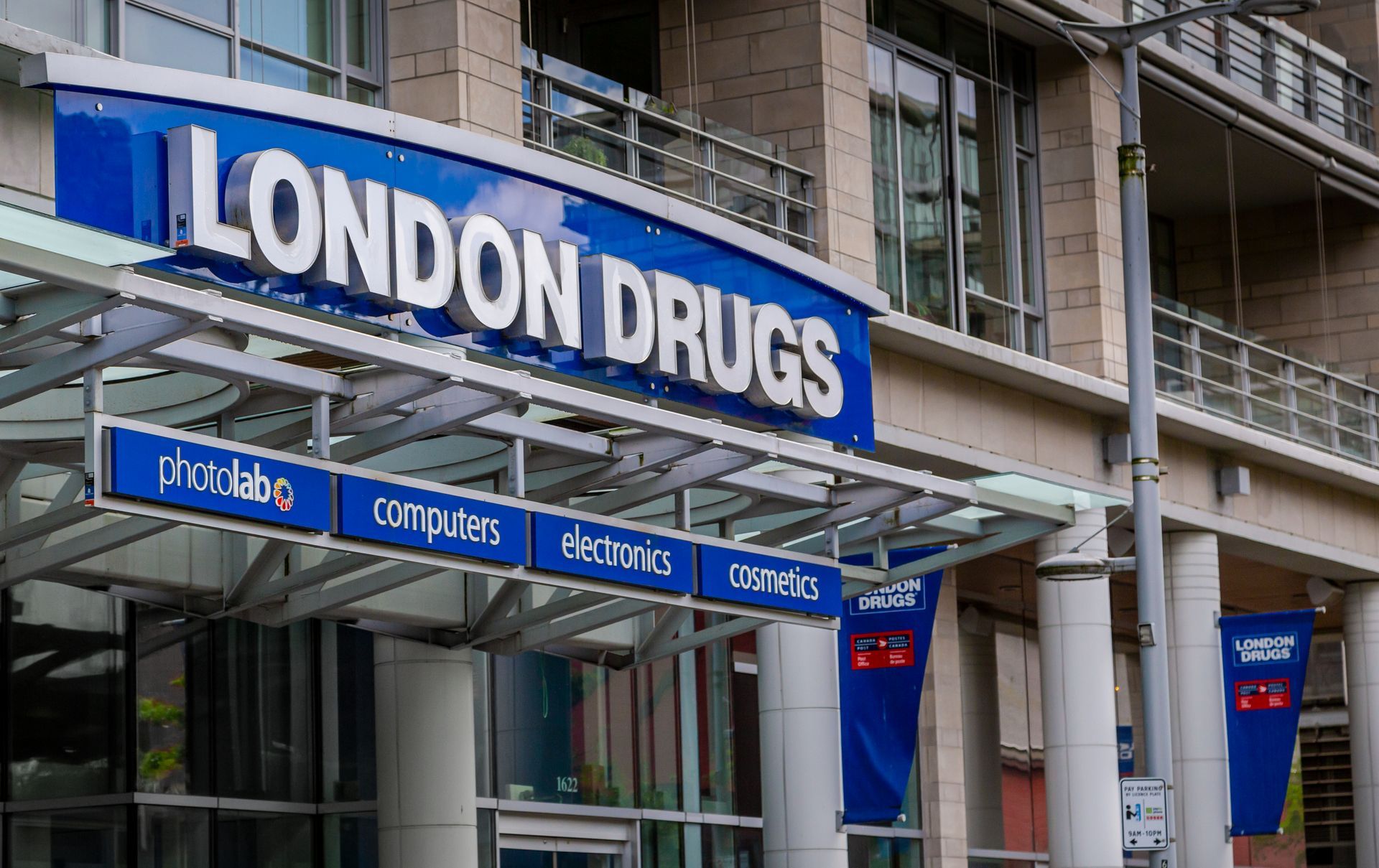 The front of a london drugs store with a canopy over the entrance.