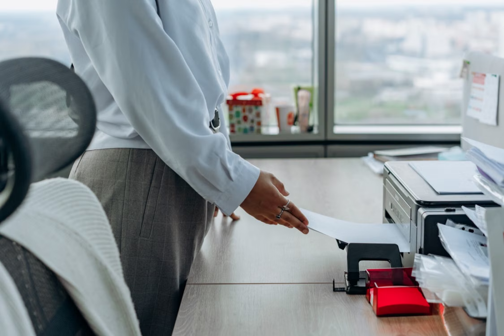 Office professional using a desktop printer supported by managed print services for reliable, uninterrupted printing.