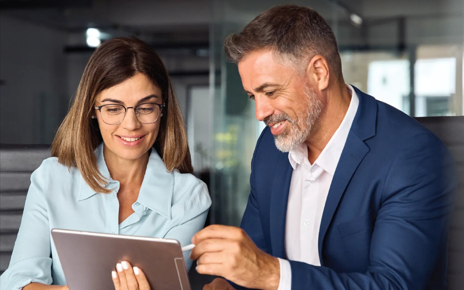 Two legal professionals reviewing information on a tablet in a law office